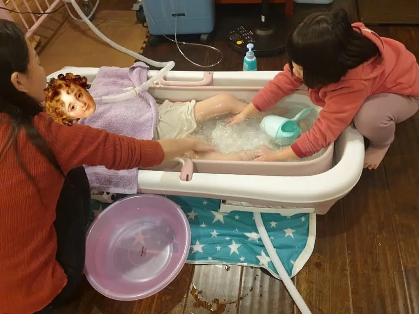 氣切兒童使用行動浴缸與洗澡枕的居家沐浴準備,氣切口保持在水面以上。